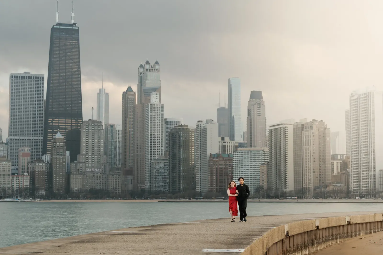A couple on the Chicago lakefront with the skyline behind