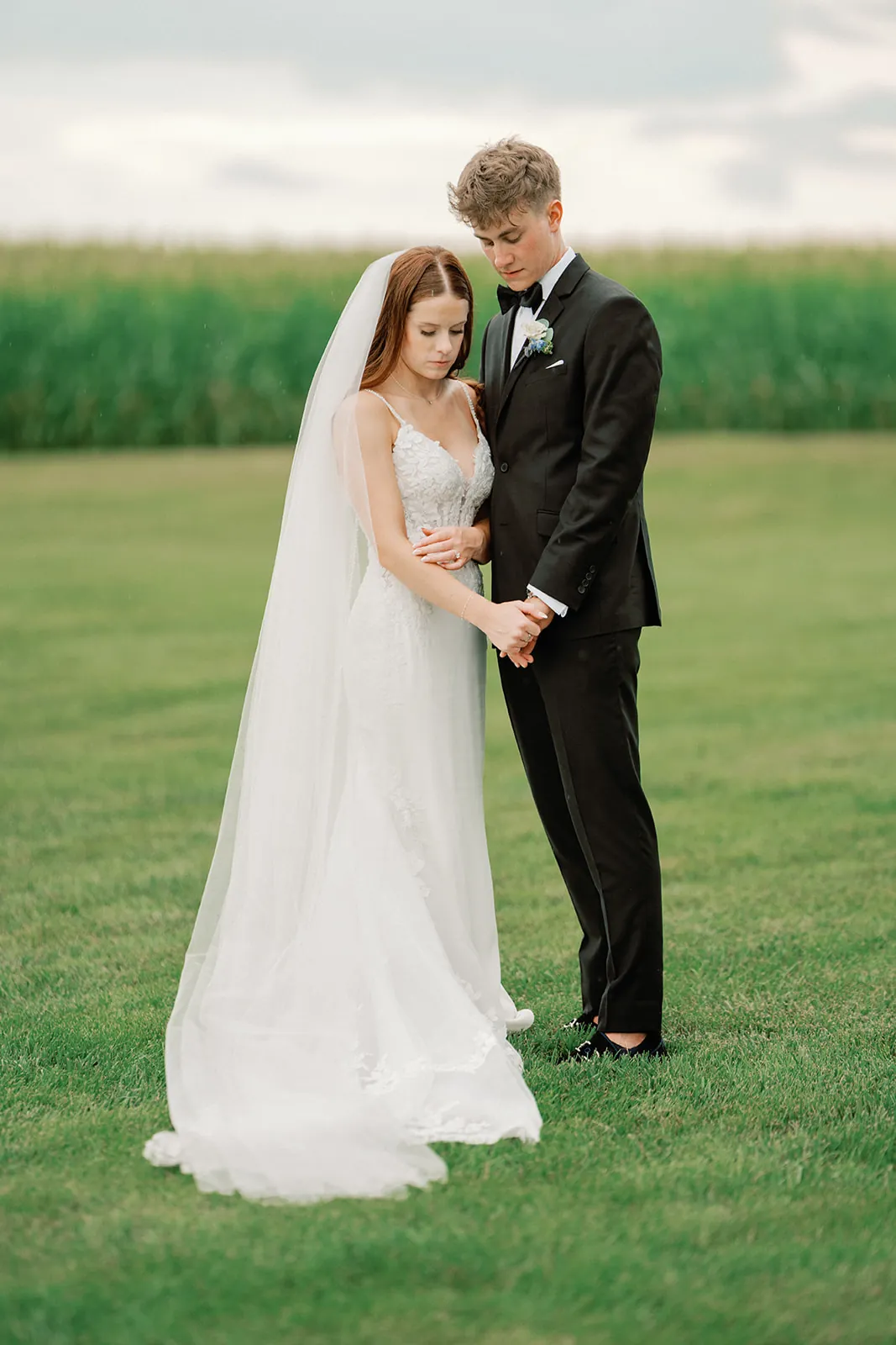 Chris and McKenna standing together in front of a cornfield