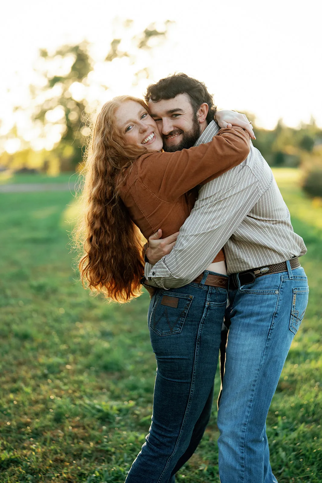 Maddy and Nathan hugging in a sunlit meadow