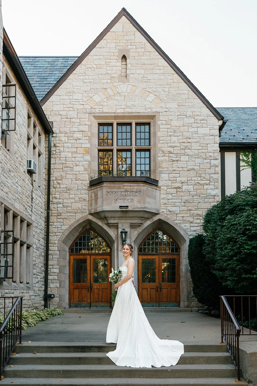 A bride on the steps of a stone venue